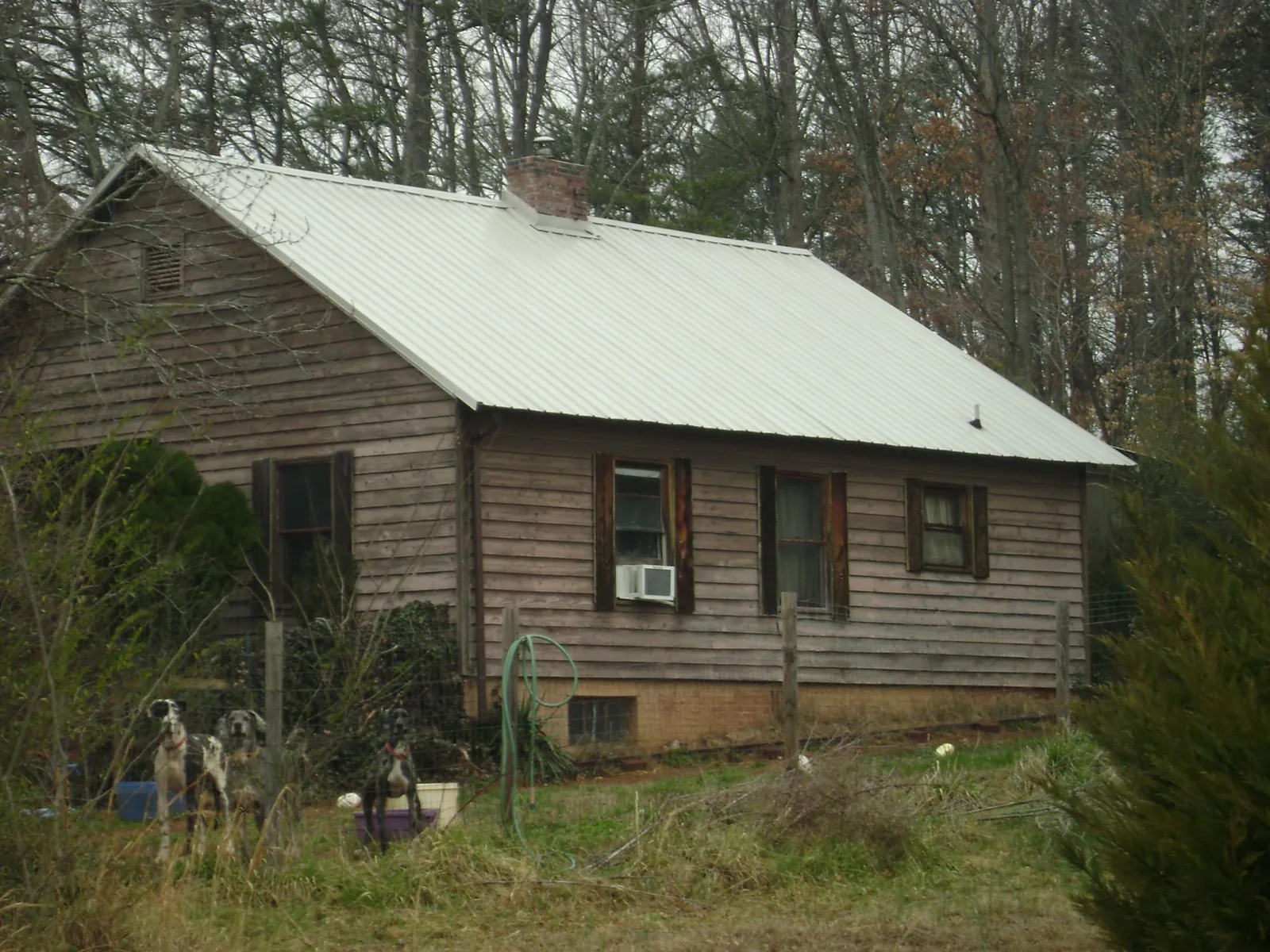 White metal roof on an old wood sided farmhouse, from a Metal Roof Installation job in De Soto